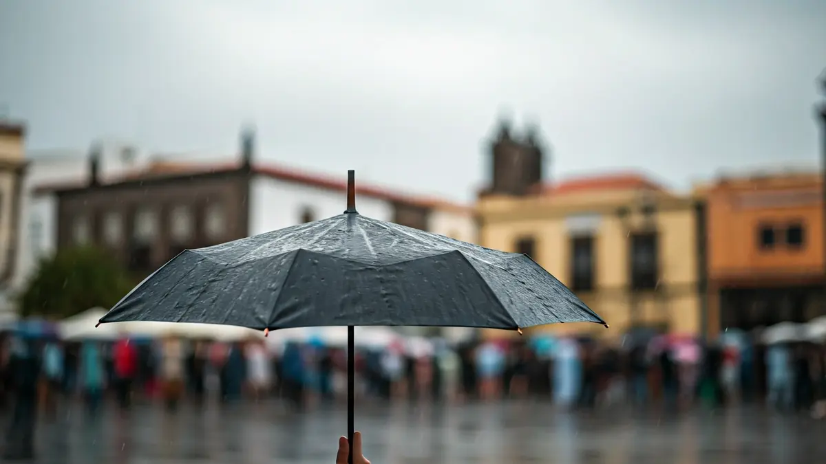 Generic image of a person with an umbrella in the rain in a Canary Island urban setting.