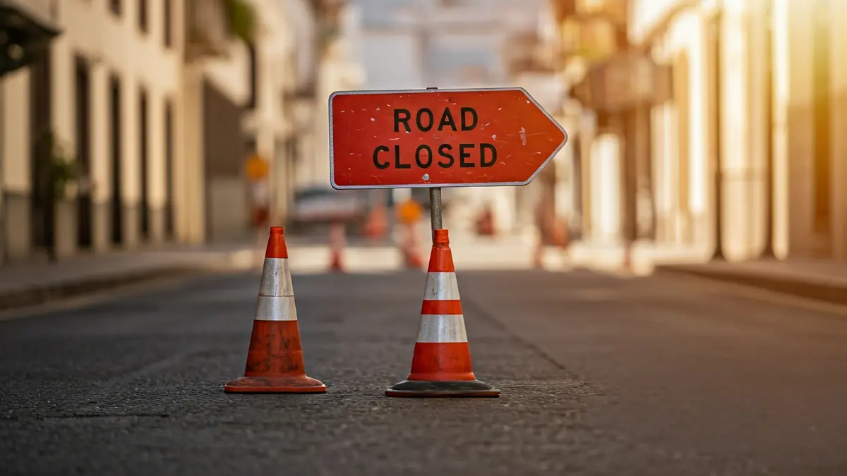 Generic image of a road closed sign with construction barriers and traffic cones.