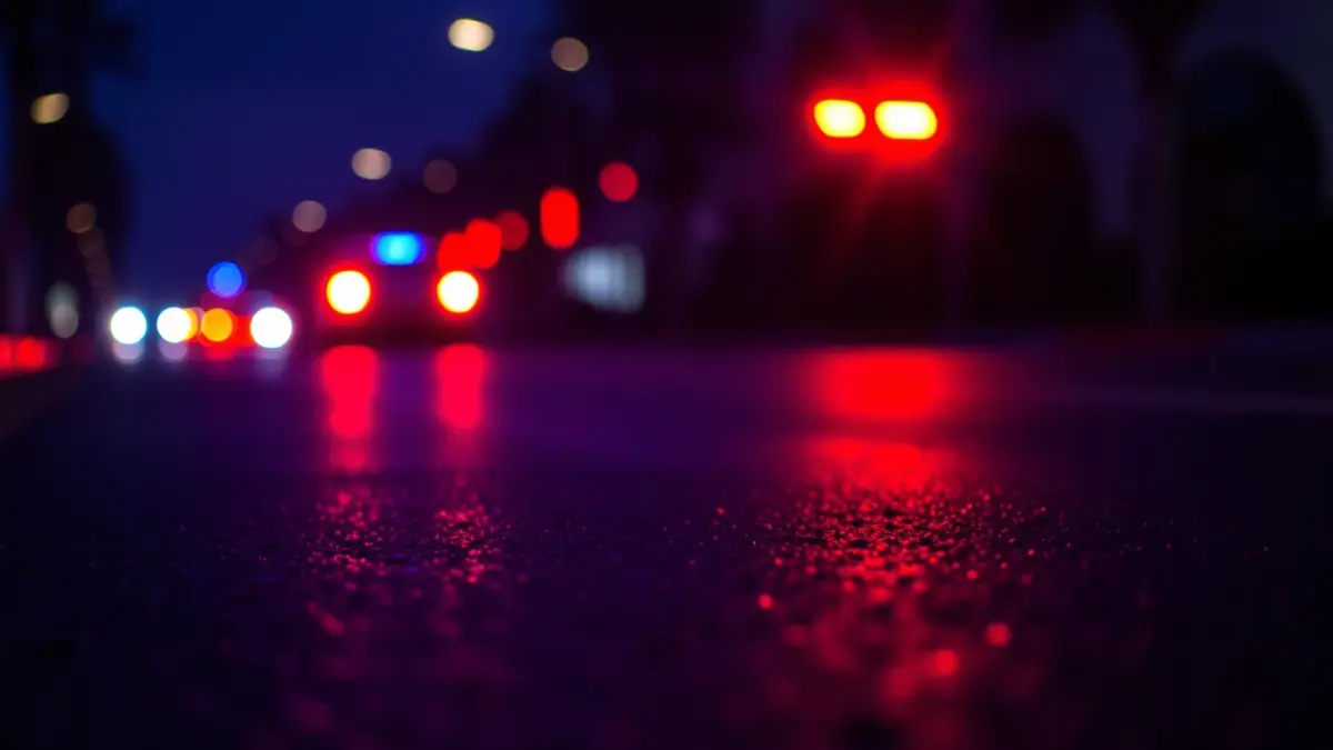 Generic image of emergency lights reflecting on wet asphalt.