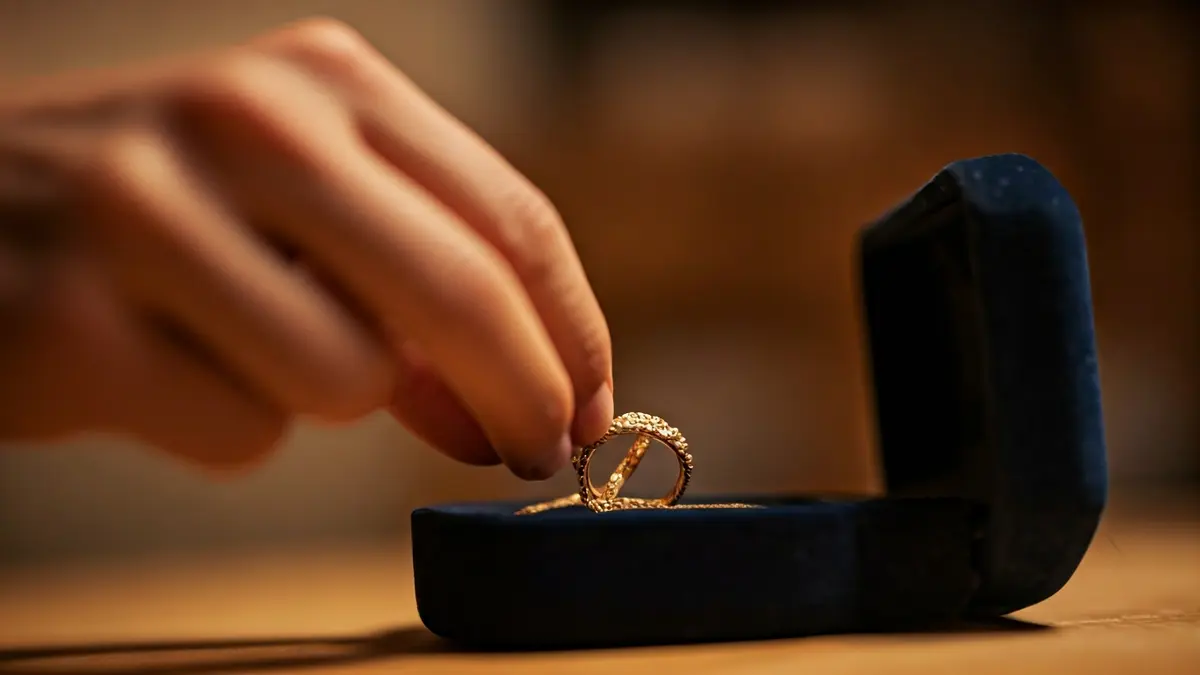 Imagen genérica de una mano colocando una joya en una caja.