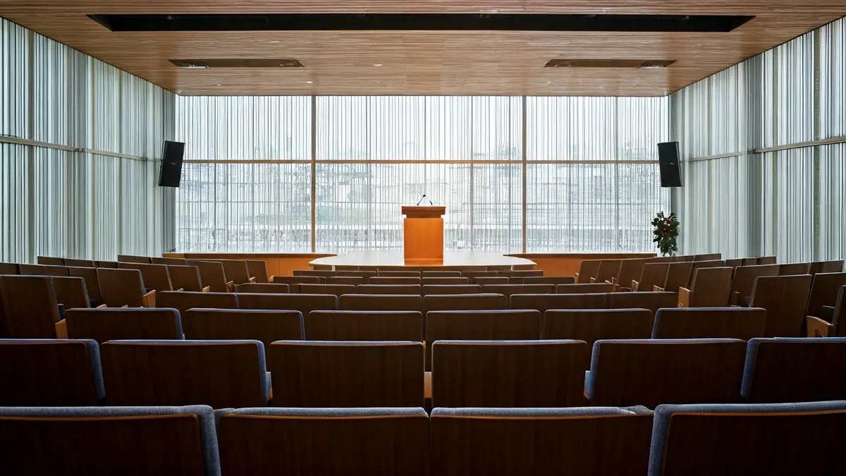 Imagen genérica de un auditorio moderno con asientos vacíos y un podio, representando un espacio de reunión comunitaria.