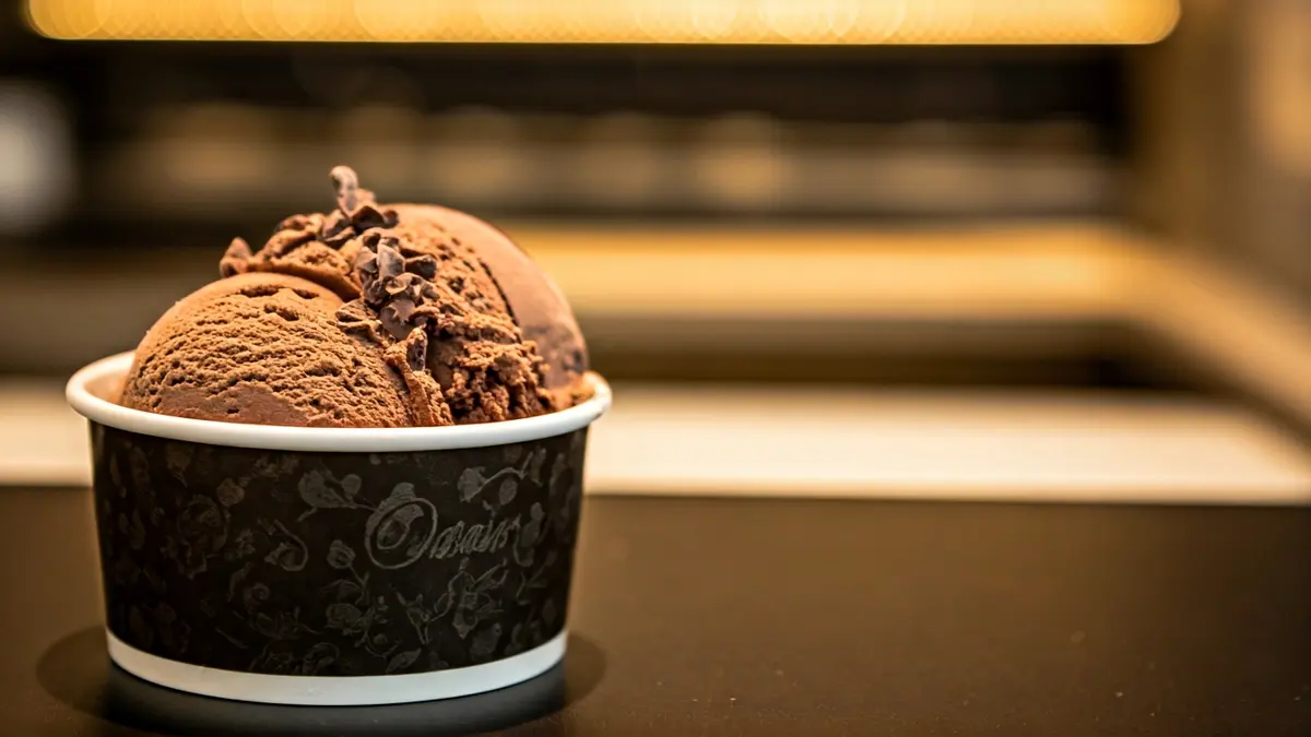 Helado de chocolate 'Origen Cacao' en una copa, con textura de nibs de cacao.