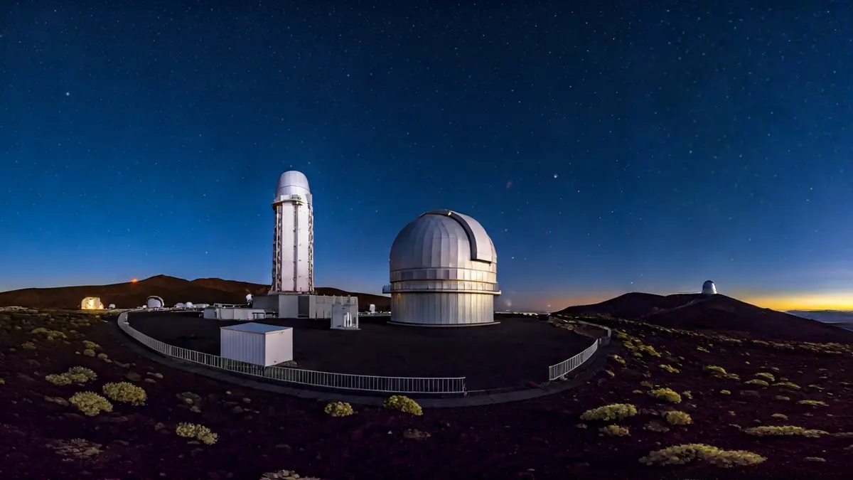 Imagen de un telescopio astronómico en un observatorio de montaña bajo un cielo estrellado.