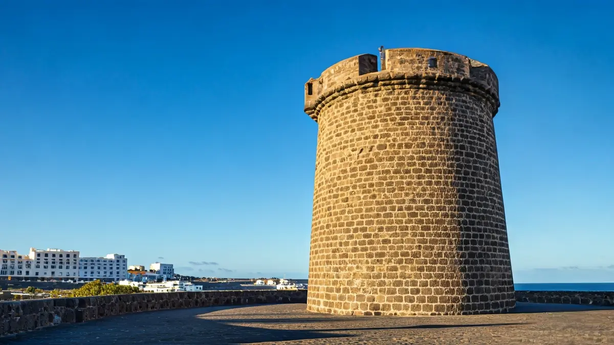 Image of a historic defensive tower in a Canarian coastal landscape.