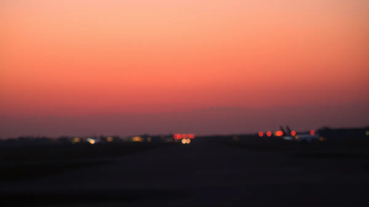 Generic image of an airport runway at dusk with emergency lights.