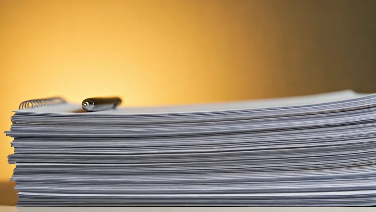 Imagen genérica de documentos oficiales y un bolígrafo, simbolizando trámites administrativos y pagos pendientes.