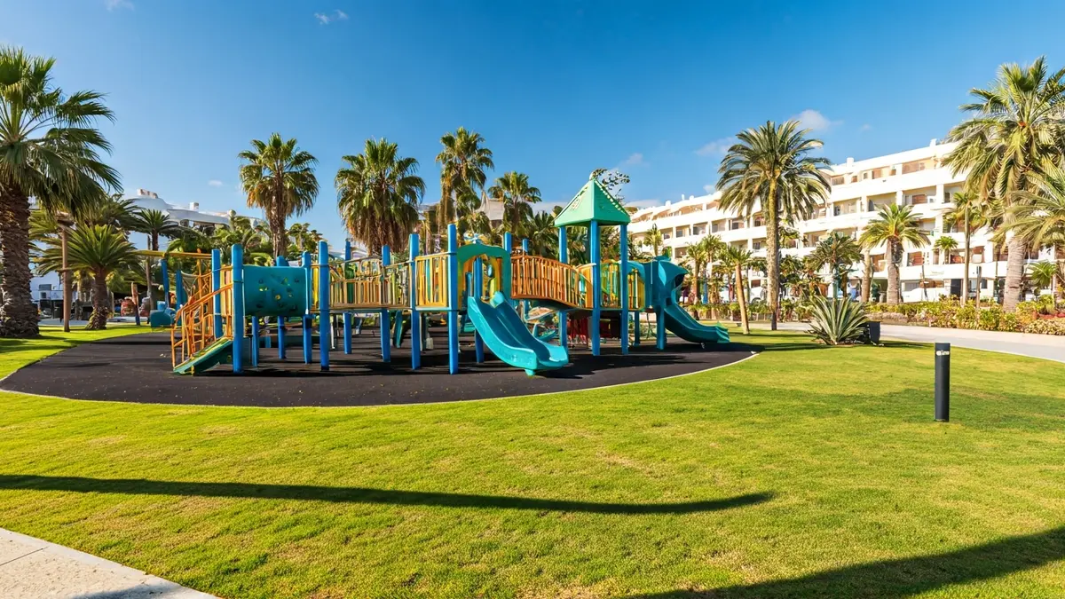 Imagen de un parque infantil renovado con césped y plantas autóctonas.