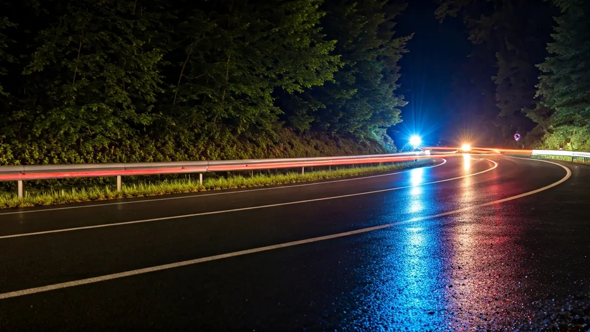 Imagen genérica de luces de emergencia en una carretera mojada por la noche.
