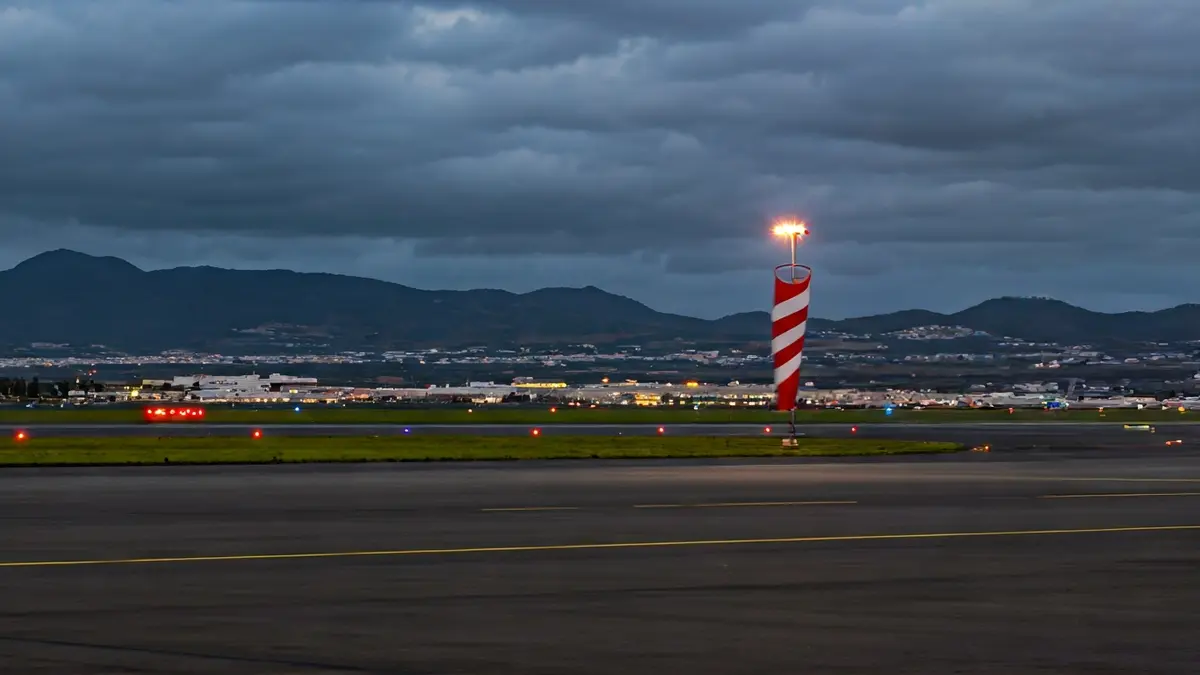 Generic image of an airport runway with strong wind at dusk.