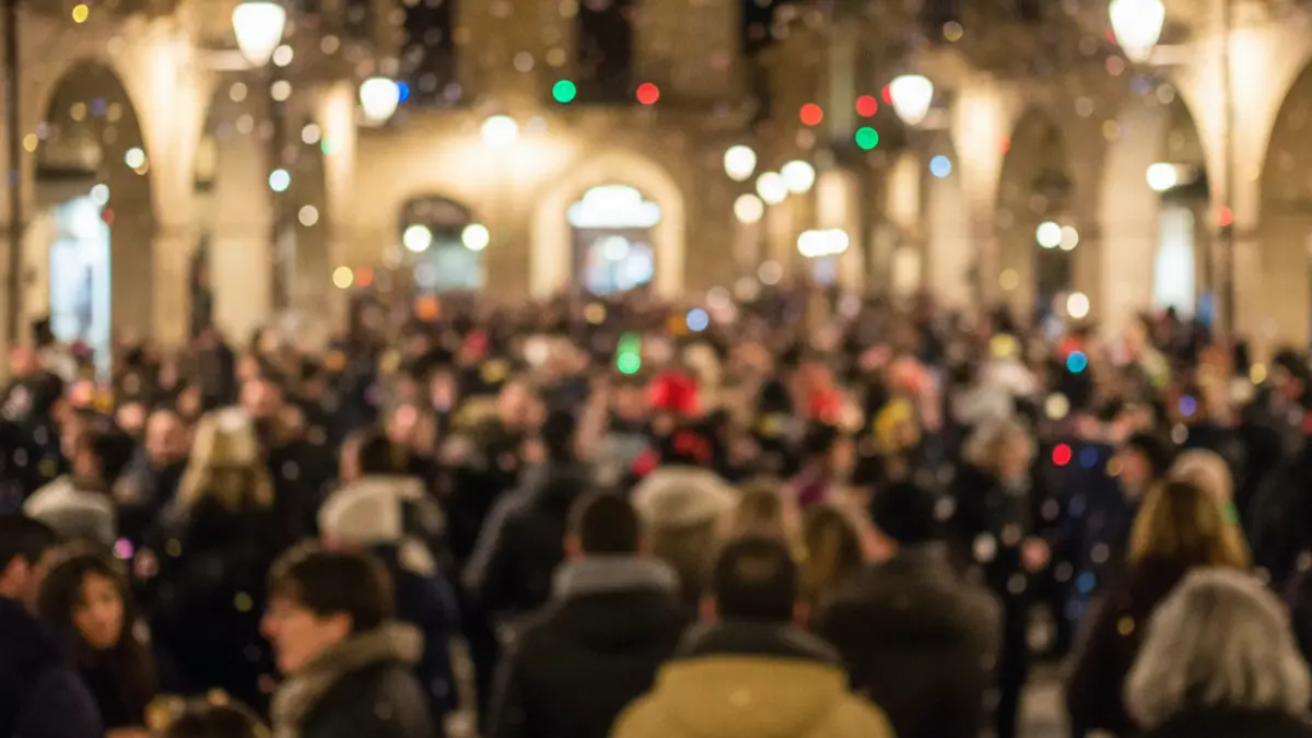 Generic image of a crowd celebrating carnival at night with lights and confetti.