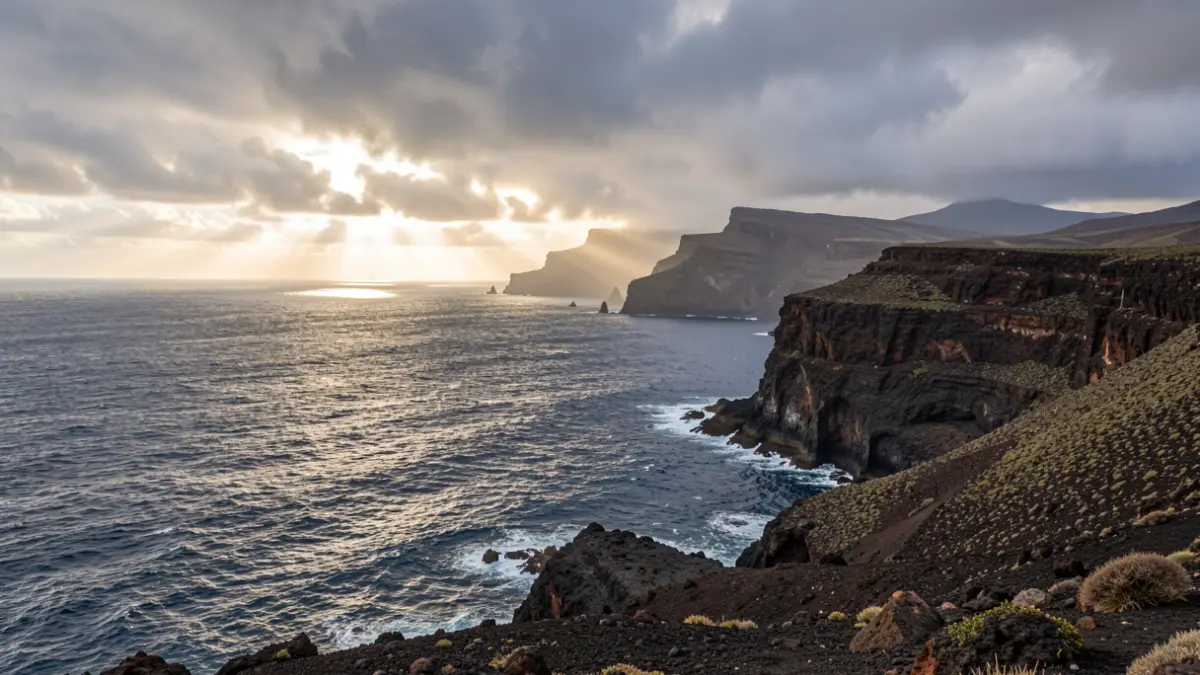 Generic image of the Canary Islands coastline with cloudy skies and ocean waves.