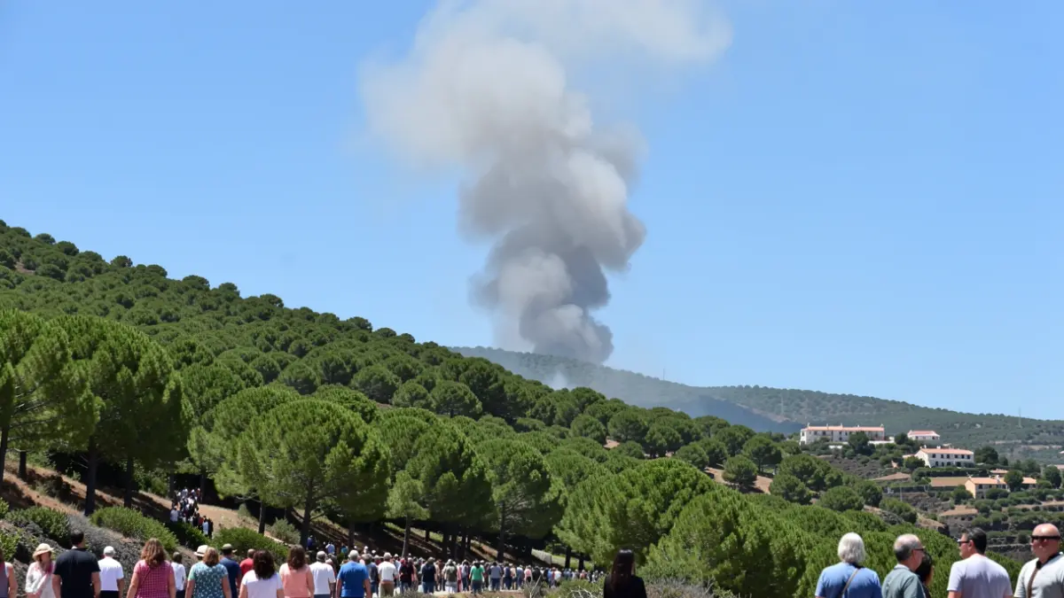 Imagen genérica de humo de un incendio forestal en una ladera con casas a lo lejos.