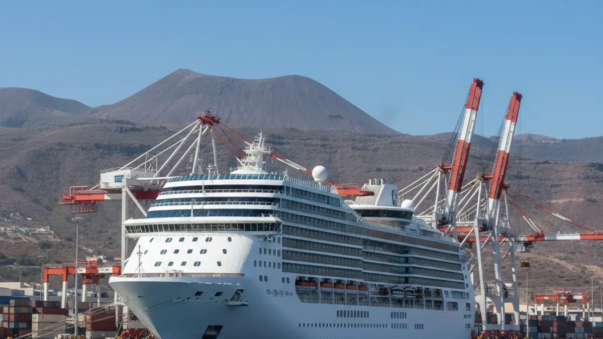 Imagen de un gran crucero atracado en el puerto de Granadilla, con el paisaje volcánico de fondo.