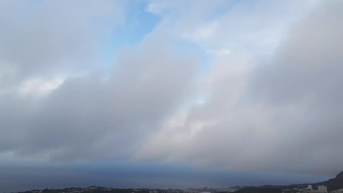 Imagen de un cielo nublado sobre una localidad costera en las Islas Canarias.