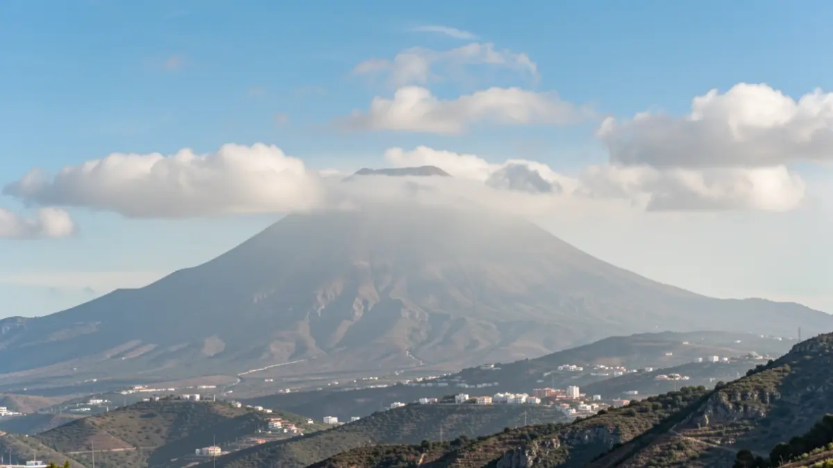 Generic image of light haze over a Canary Islands volcanic landscape with variable clouds.
