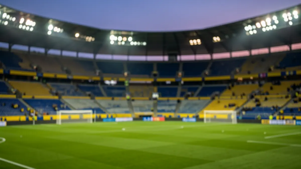 Imagen genérica de un estadio de fútbol al atardecer con el césped iluminado.