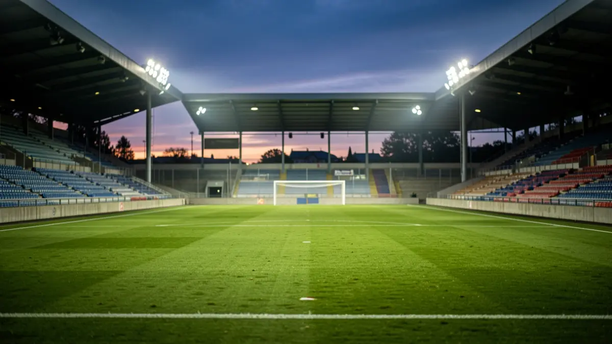 Imagen genérica de un campo de fútbol al atardecer con luces.