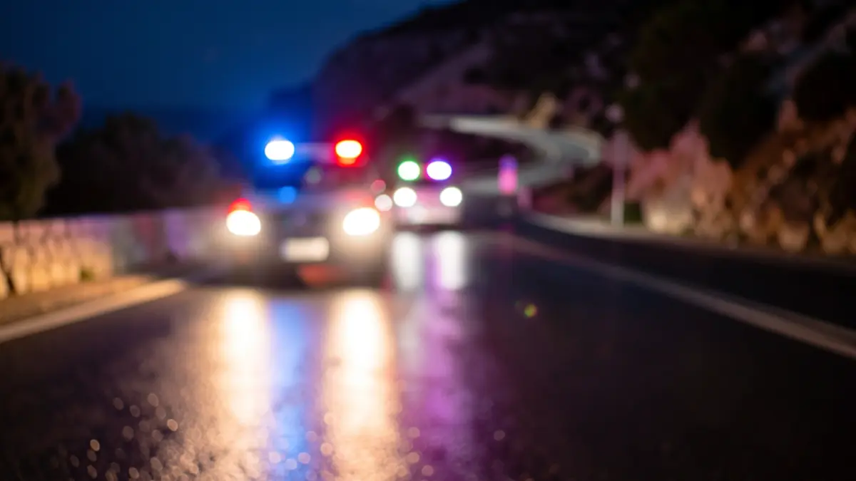 Imagen genérica de luces de emergencia en una carretera mojada por la noche.