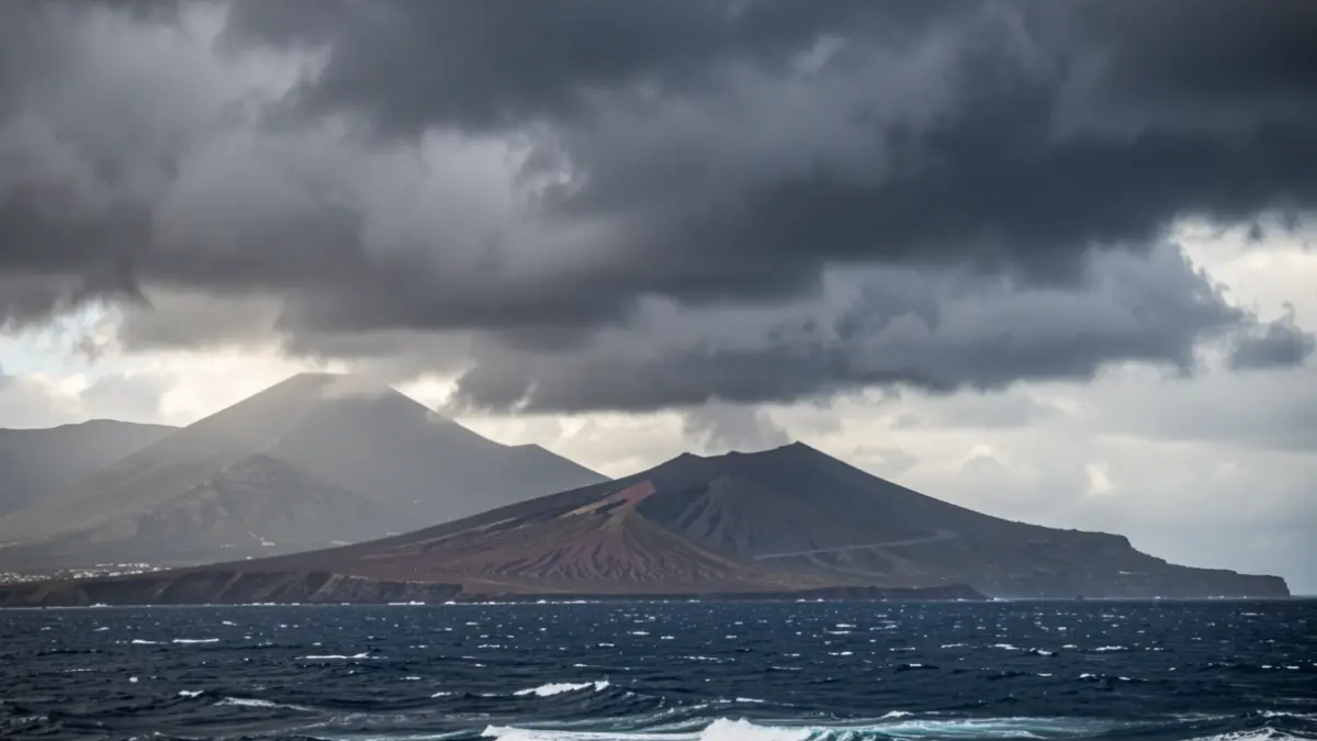 Imagen genérica de nubes de tormenta y viento sobre un paisaje volcánico canario con mar agitado.