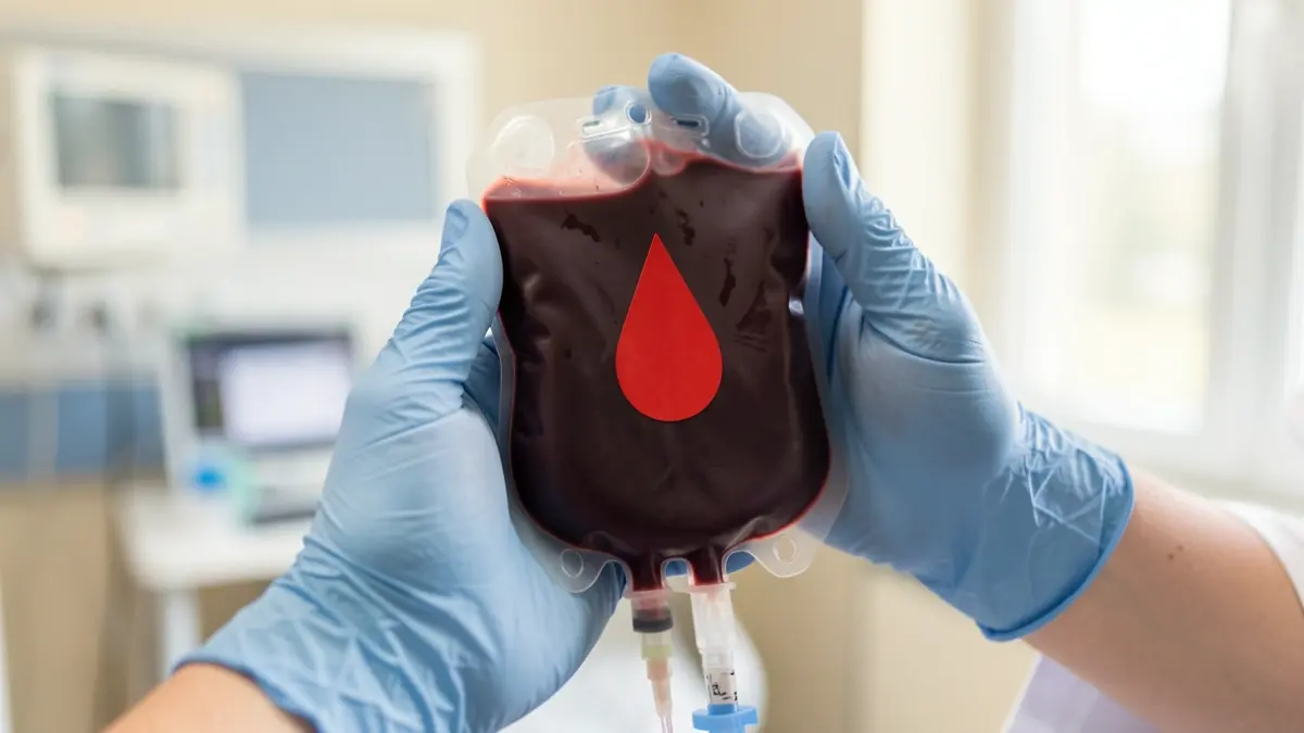Imagen genérica de una bolsa de sangre siendo sostenida por personal médico.