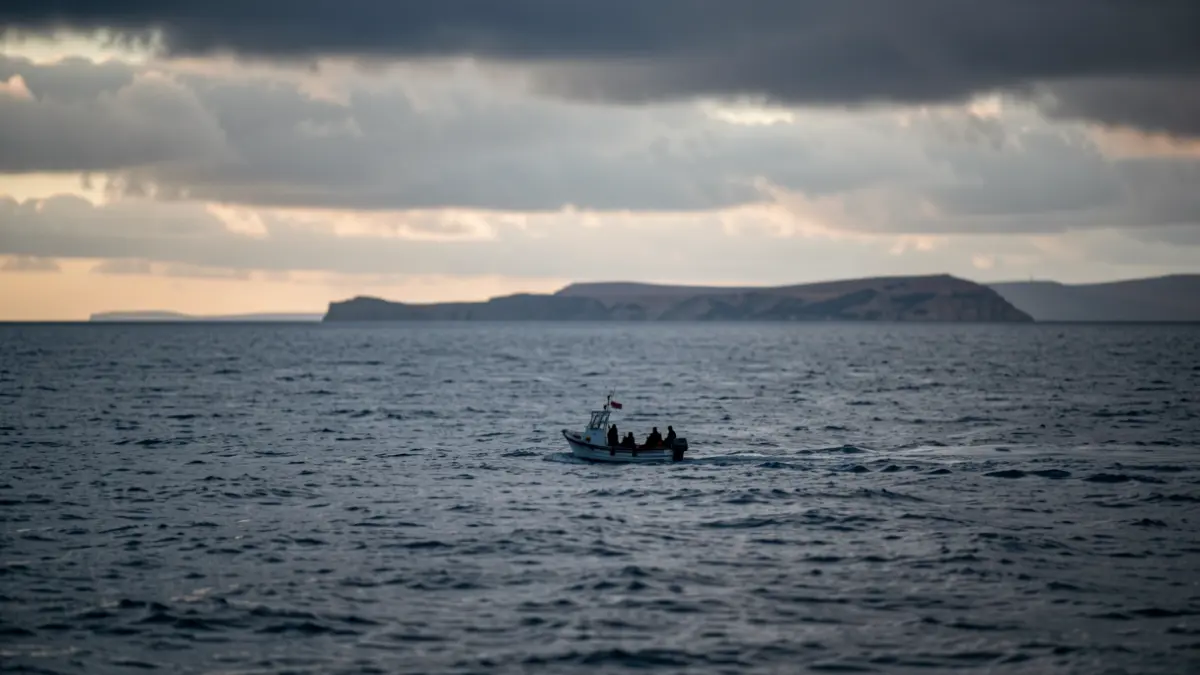 Imagen simbólica de un bote con figuras al atardecer frente a la costa.