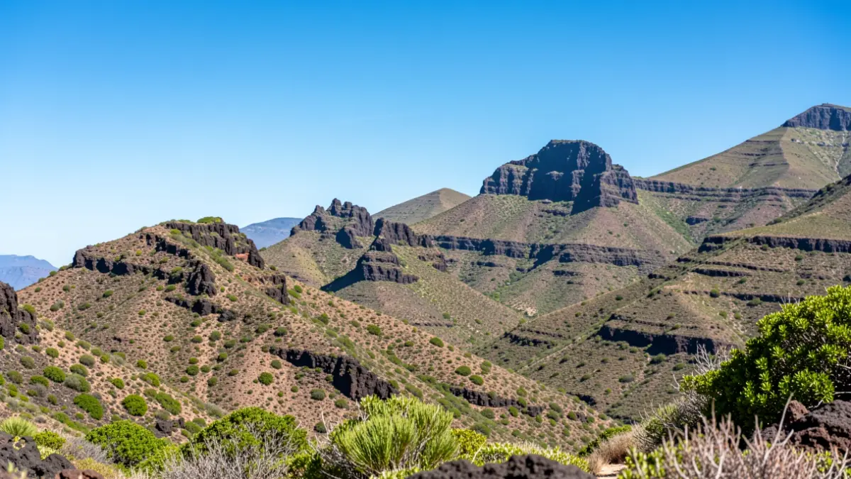 Cielo despejado y soleado sobre un paisaje montañoso en Canarias.