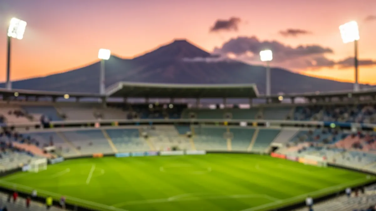 Imagen genérica de un estadio de fútbol en Canarias al atardecer, con el campo iluminado y el paisaje volcánico al fondo.