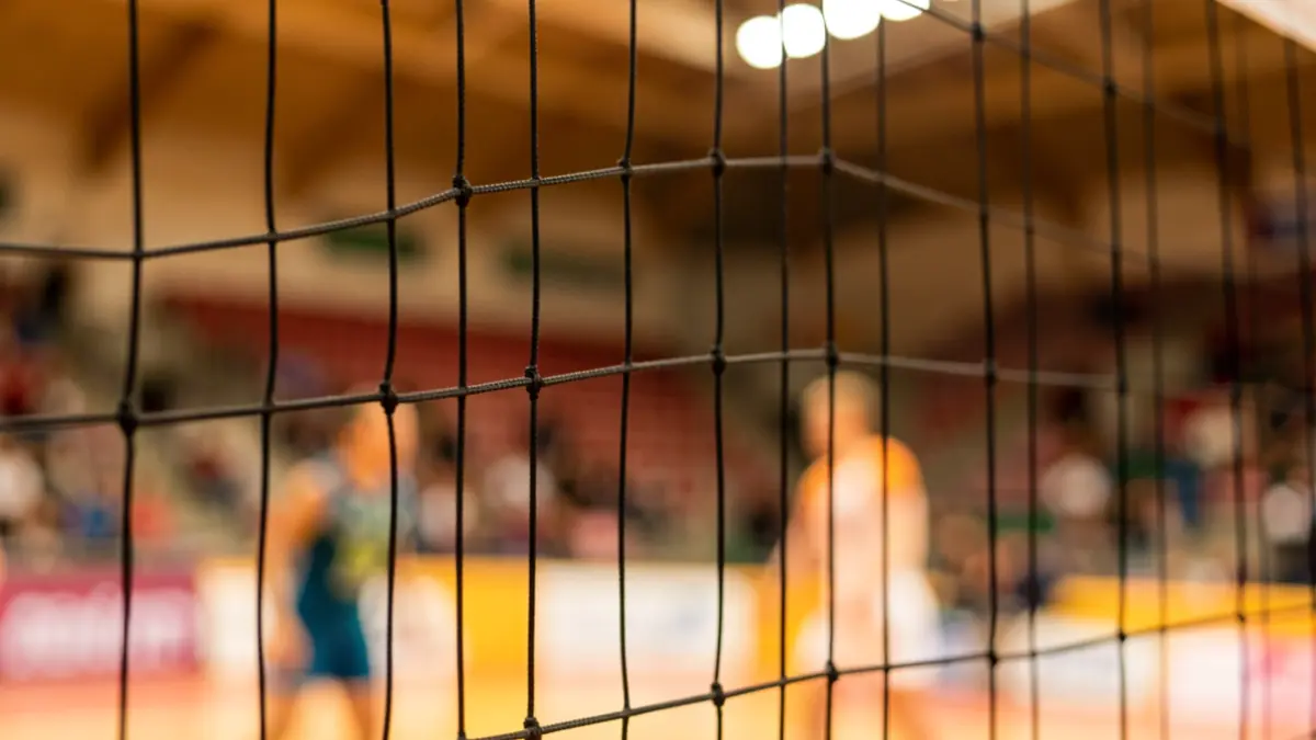 Generic image of a volleyball net in a sports arena.