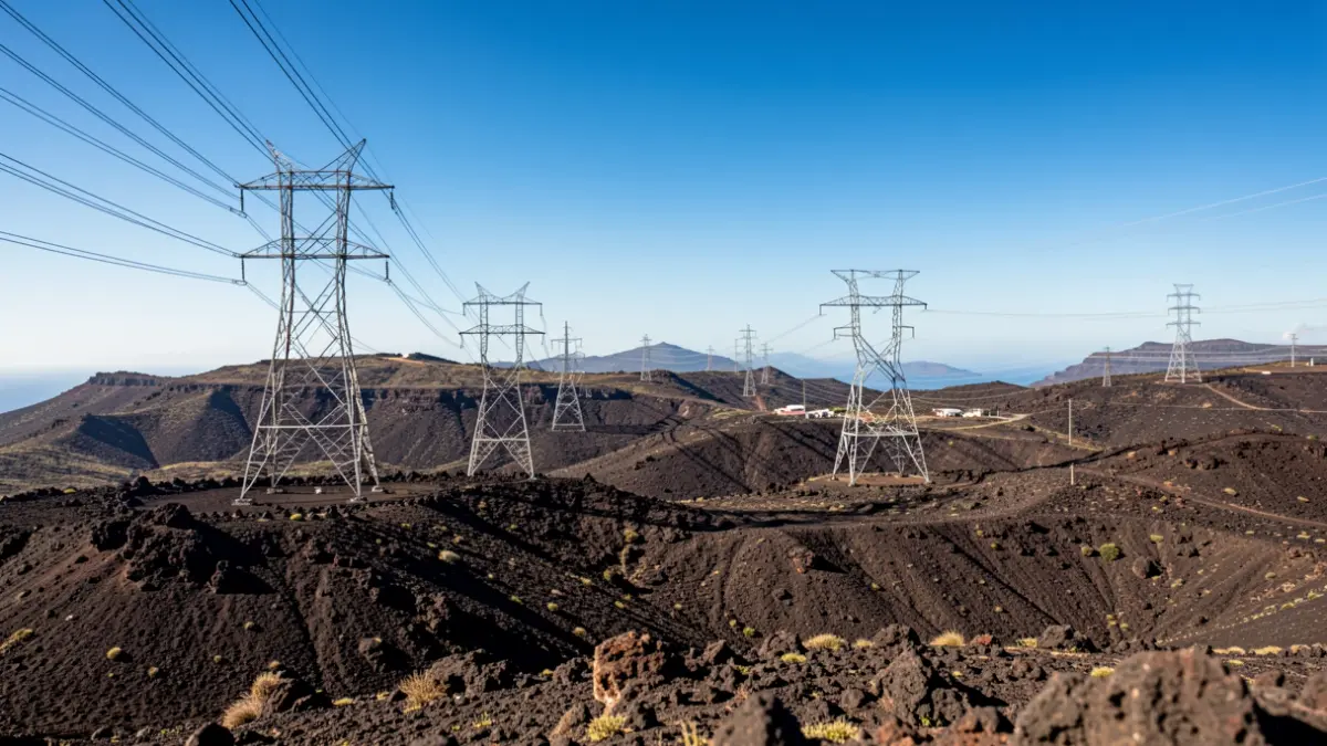 Generic image of high-voltage transmission towers in a volcanic landscape.