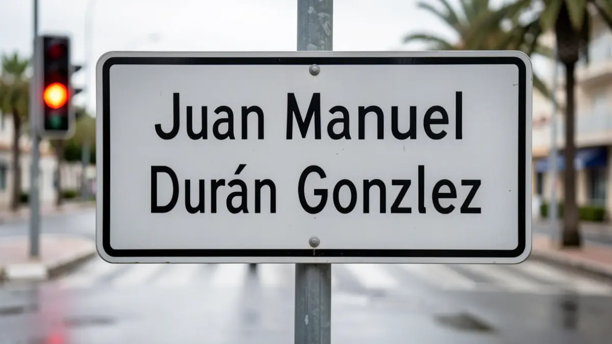 Señal de calle 'Juan Manuel Durán González' con luces de tráfico borrosas y asfalto mojado, indicando el fin de las obras en Las Palmas de Gran Canaria.