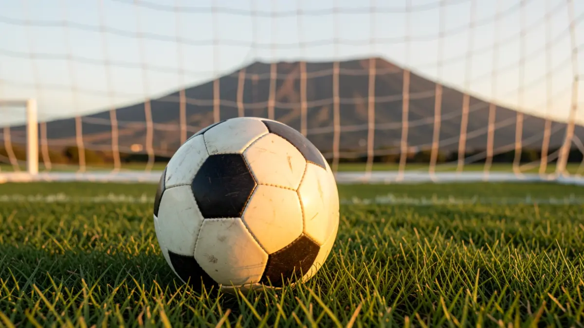 Generic image of a soccer ball on grass with the landscape of Tenerife in the background.