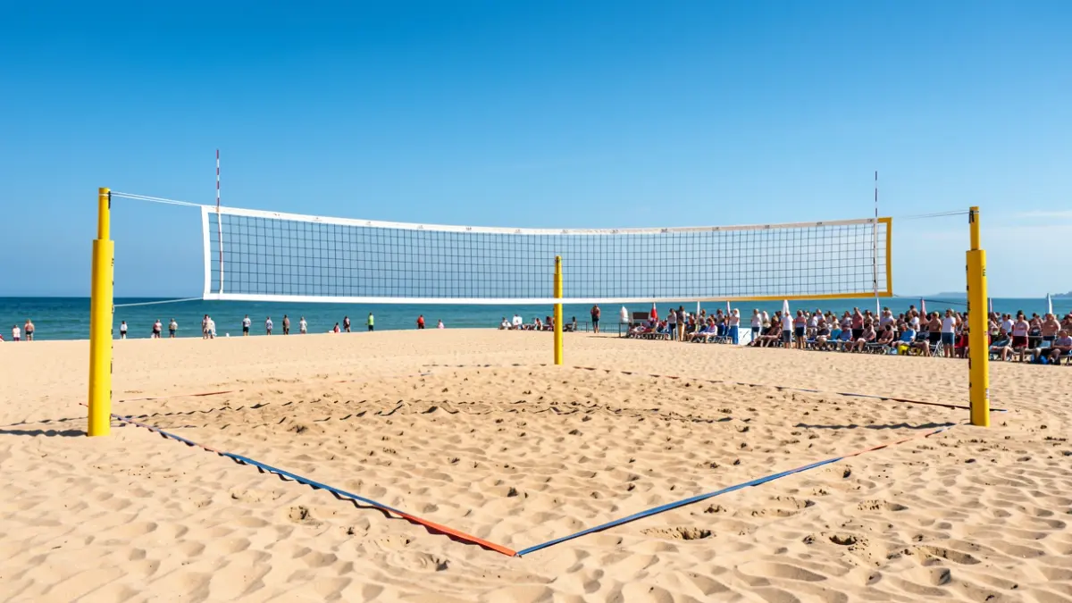 Beach volleyball court with nets set up and the sea in the background.