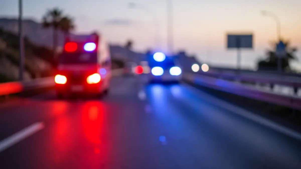 Imagen genérica de una carretera en Canarias con luces de emergencia reflejándose en el asfalto mojado.