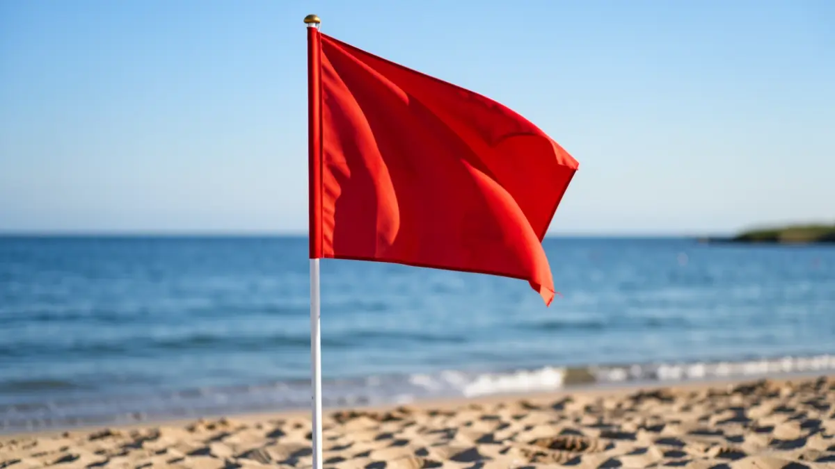 Red flag waving at Leocadio Machado beach, indicating temporary closure to swimming.
