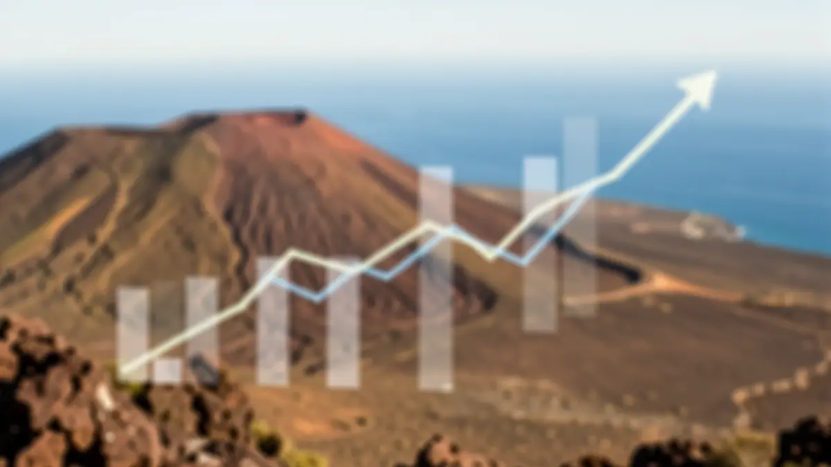 Abstract economic graphs with a downward trend over a volcanic landscape of Canarias.