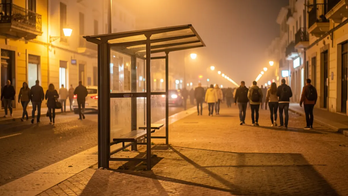 Imagen genérica de una parada de autobús vacía bajo luz cálida de noche.