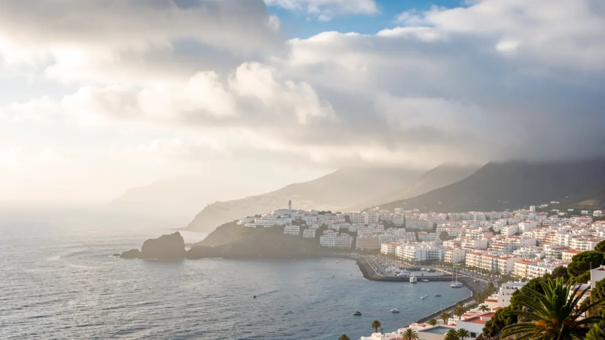 Generic image of a partly cloudy sky over a coastal town in the Canary Islands with morning fog.