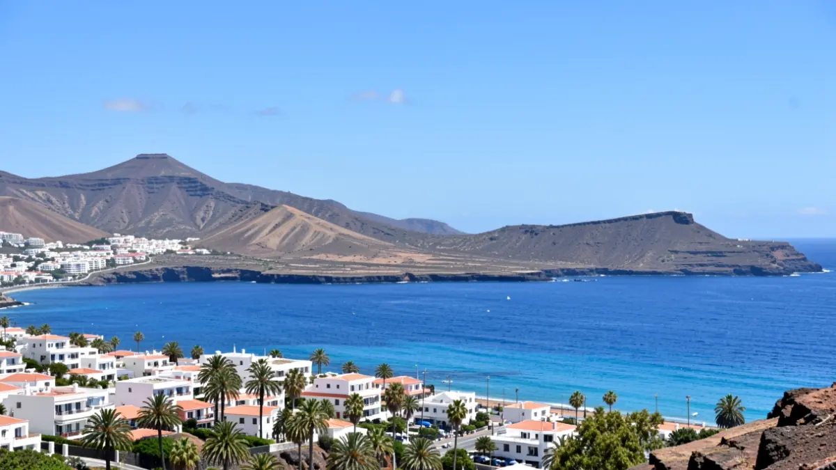 Cielo despejado sobre Tuineje, Fuerteventura, con paisaje volcánico y mar azul.