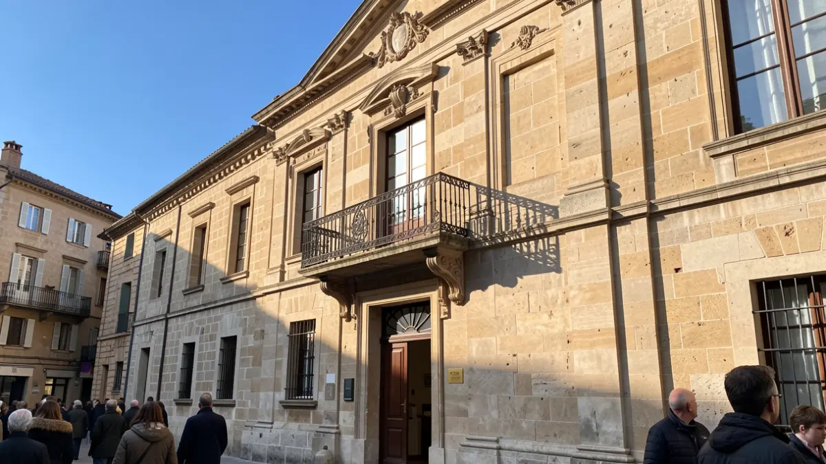 Facade of a traditional Canarias town hall with balcony and iron railings, warm afternoon sunlight.