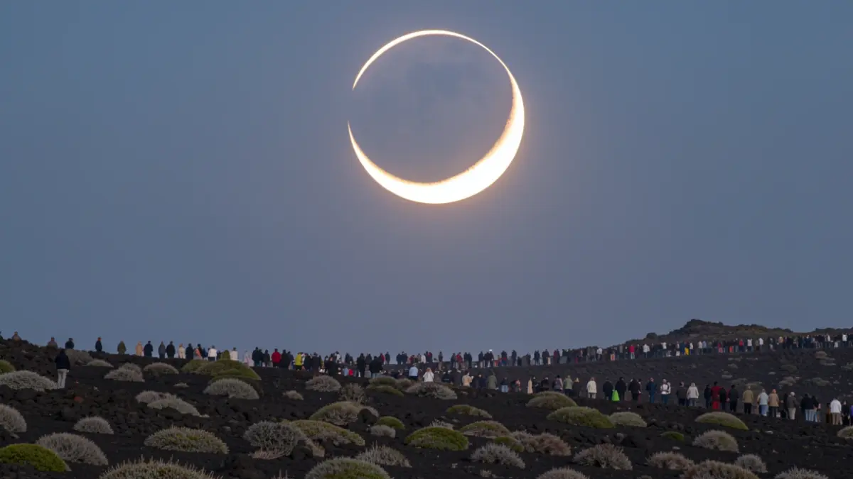 Image of a solar eclipse seen from a volcanic landscape in the Canary Islands.