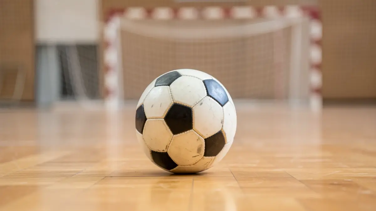 Generic image of a handball ball on a court's wooden floor.