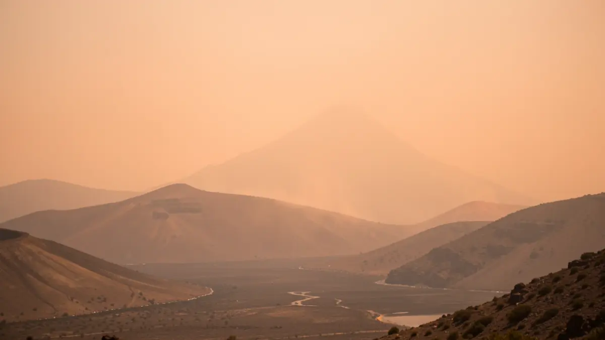 Cielo brumoso sobre un paisaje volcánico de Canarias con un tinte anaranjado por el polvo en suspensión.