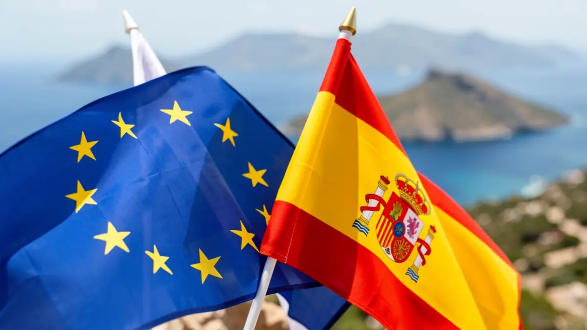Flags of the European Union and Spain in front of a landscape of the Canary Islands.