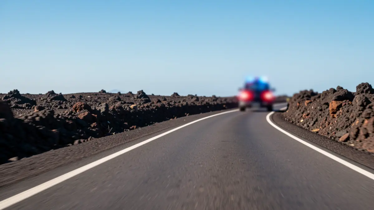 Imagen genérica de una carretera secundaria en Lanzarote con luces de emergencia de la Guardia Civil.