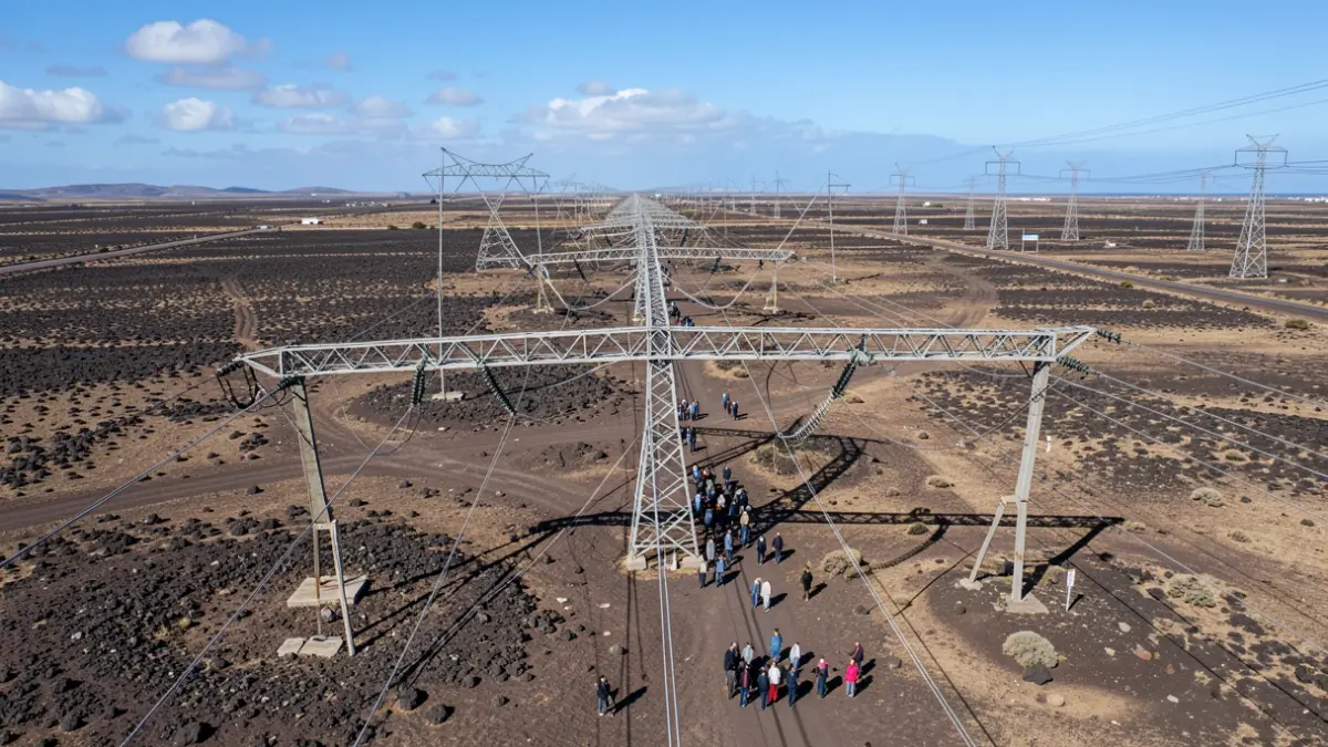 Vista aérea de una antigua línea eléctrica siendo desmantelada en Fuerteventura, con la nueva red visible al fondo.