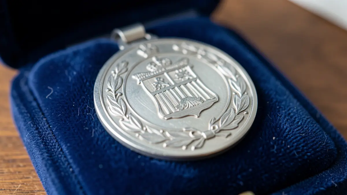 Primer plano de una medalla de plata al Mérito Policial sobre un cojín de terciopelo azul.
