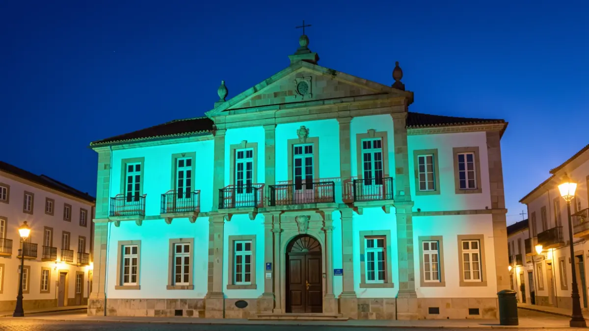 Facade of the Telde Town Hall illuminated in turquoise at dusk.