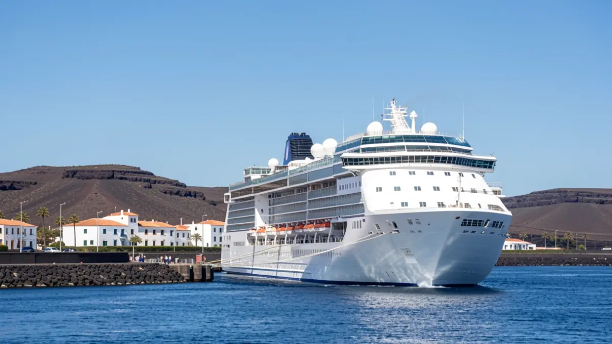 Imagen genérica de un crucero atracado en un puerto con paisaje volcánico y arquitectura canaria.