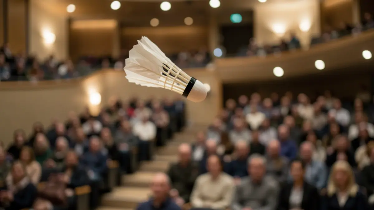 Generic image of a badminton shuttlecock in the air in an empty auditorium.