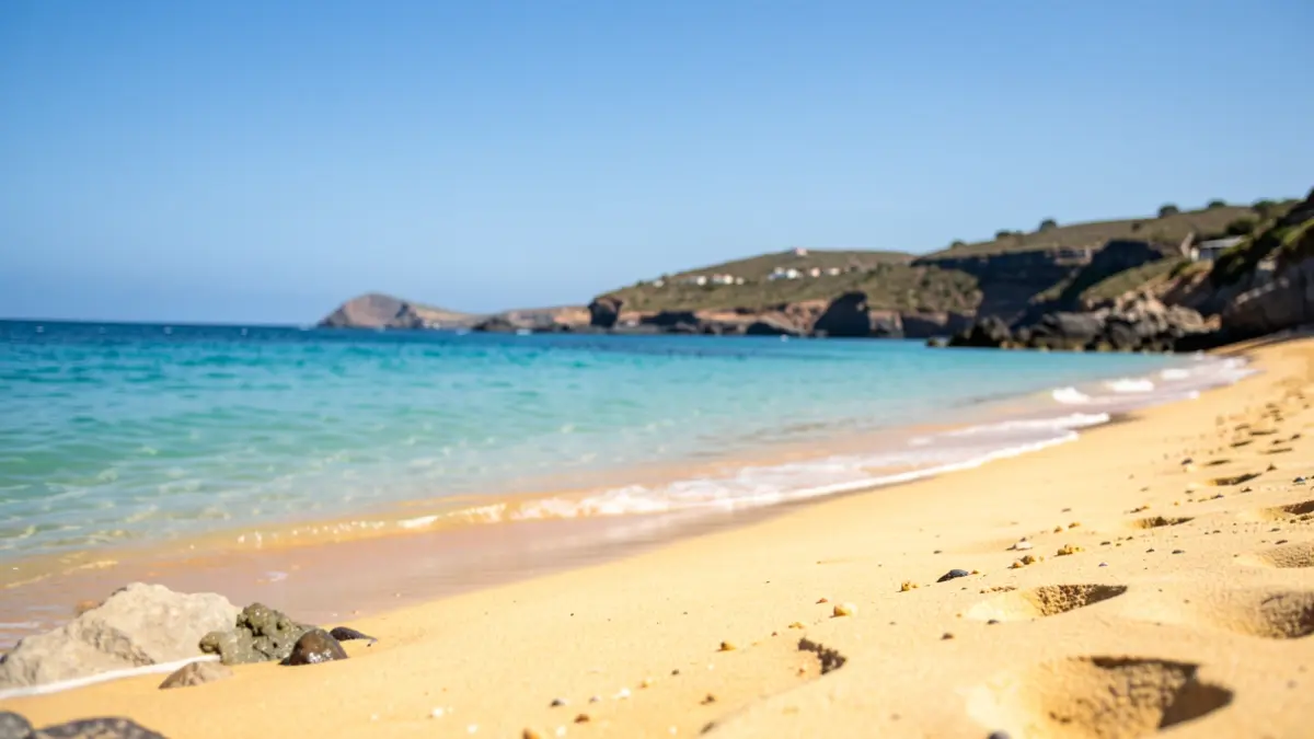 Generic image of a Canary Islands beach with golden sand and calm waters under a blue sky.